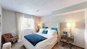 Columbus apartment for rent - a bedroom with a bed and a chair and a window at Runaway Bay Apartments, Columbus, Ohio