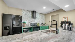Memphis apartment for rent - A kitchen with a marble countertop and green cabinets.