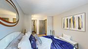Westerville apartment for rent - a bedroom with a large bed and a mirror on the wall at Silvertree at Little Turtle Apartments, Westerville, Ohio