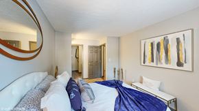 Westerville apartment for rent - a bedroom with a large bed and a mirror on the wall at Silvertree at Little Turtle Apartments, Westerville, Ohio