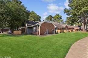 Memphis apartment for rent - a small brick house with a yard and trees at The Birches Apartment Homes, Memphis, TN