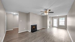 Memphis apartment for rent - A spacious room with a fireplace and a ceiling fan.