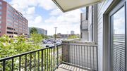 Memphis apartment for rent - A balcony with a black railing overlooks a parking lot and buildings.