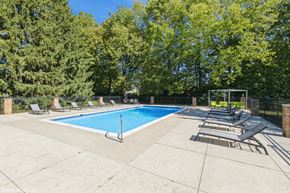 Dublin apartment for rent - A pool surrounded by trees and lounge chairs at Karric Place of Dublin Apartments, Dublin, OH