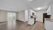 Memphis apartment for rent - A kitchen with white cabinets and a black fridge. at The Stella Apartments, Memphis, Tennessee