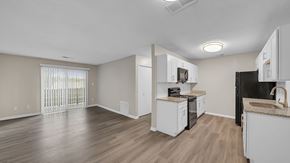 Memphis apartment for rent - A kitchen with white cabinets and a black fridge. at The Stella Apartments, Memphis, Tennessee