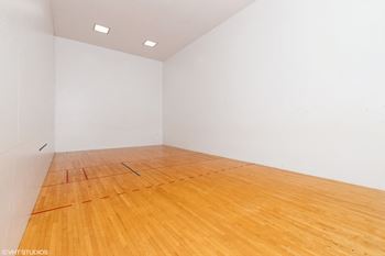 A room with wooden floor and white walls.