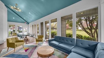 Memphis apartment for rent - A brightly lit living room with a blue couch and yellow chairs.