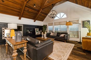 A living room with a black couch and a wooden table.