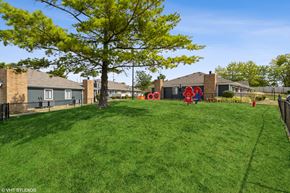 Columbus apartment for rent - a yard with a playground and houses in the background at Springburne at Polaris Apartments, Columbus, 43235