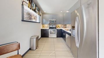 Tacoma apartment for rent - A modern kitchen with stainless steel appliances and a wooden bench.