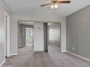 Houston apartment for rent - A spacious room with a ceiling fan and a glass door.