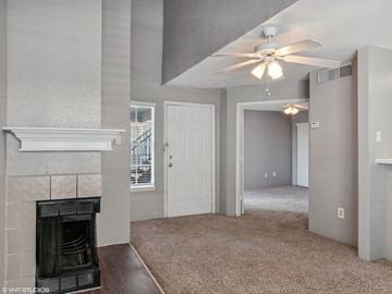 Houston apartment for rent - A living room with a fireplace and a ceiling fan.