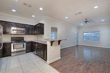 San Marcos apartment for rent - A kitchen with dark wood cabinets and stainless steel appliances.