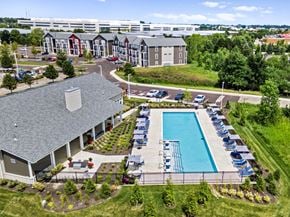 Columbus apartment for rent - A large building with a pool in front of it.