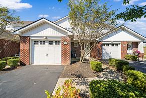 Westerville townhouse for rent - A house with a white garage door and a tree in front.