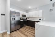 Columbus apartment for rent - A modern kitchen with a stainless steel refrigerator and wooden flooring.
