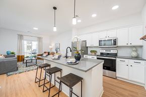 Mount Vernon apartment for rent - A kitchen with white cabinets and a large island with a sink and bar stools.