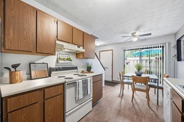 Columbus townhouse for rent - A kitchen with wooden cabinets and a white stove top oven.