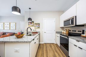Marysville apartment for rent - A kitchen with white cabinets and a granite countertop.