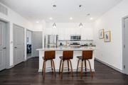 Columbus apartment for rent - A kitchen with white cabinets and a white island with two bar stools.