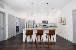 Columbus apartment for rent - A kitchen with white cabinets and a white island with two bar stools.