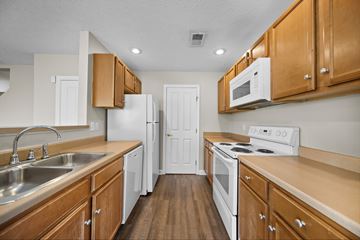 Westerville townhouse for rent - A kitchen with wooden cabinets and white appliances.