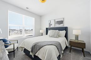 Marysville apartment for rent - A bedroom with a large bed and a window with blinds.