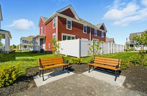 Powell townhouse for rent - Two wooden benches are placed in front of a red building.