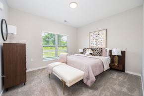 Columbus apartment for rent - A bedroom with a large bed and a window with blinds.