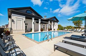 Sunbury apartment for rent - A pool area with sun loungers and a building in the background.