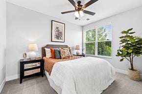 Columbus apartment for rent - A bedroom with a bed, nightstand, and a ceiling fan.