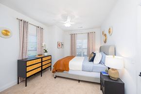 Mount Vernon apartment for rent - A bedroom with a bed, nightstand, and a dresser with a plant on top.
