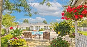 Westerville apartment for rent - a backyard with a pool and chairs and flowers