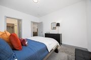 Columbus apartment for rent - A bedroom with a bed, dresser, mirror and a chair.
