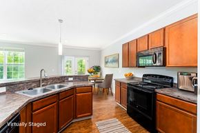 Lewis Center townhouse for rent - A kitchen with wooden cabinets and a black stove top oven.