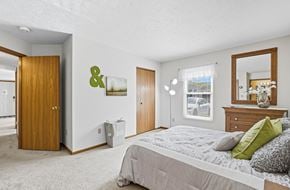 Marysville apartment for rent - A bedroom with a large bed and a mirror on the dresser.