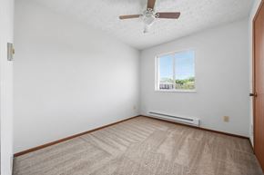 Columbus townhouse for rent - A room with a ceiling fan and a window with a view of trees and a fence outside.