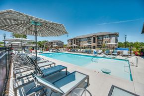 Columbus apartment for rent - A sunny day at the pool with lounge chairs and umbrellas.