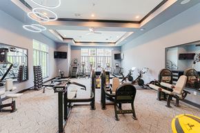 Columbus apartment for rent - A spacious gym with various exercise equipment and mirrors.