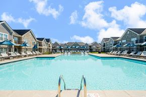 Mount Vernon apartment for rent - A large swimming pool surrounded by lounge chairs and umbrellas.