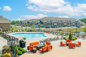 Grove City townhouse for rent - an outdoor pool with orange chairs and tables and a building in the background