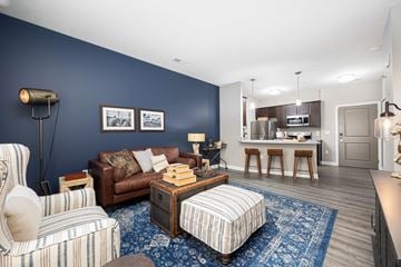 Hilliard apartment for rent - a living room with a couch and a chair in front of a kitchen