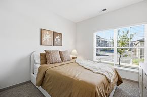 Grove City apartment for rent - A bedroom with a large bed and two pictures on the wall.