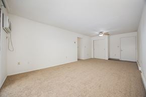 Newark apartment for rent - A room with carpeted floor and a ceiling fan.
