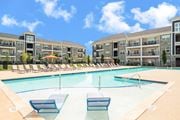 Columbus apartment for rent - a swimming pool with lounge chairs in front of an apartment building