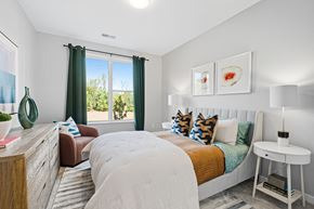 Columbus apartment for rent - A bedroom with a large bed and a window with green curtains.