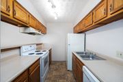 Galloway apartment for rent - a kitchen with white appliances and wooden cabinets