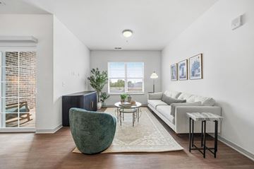 Columbus apartment for rent - A living room with a green chair and a white couch.
