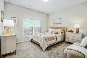 Sunbury apartment for rent - a bedroom with a bed and a dresser and a window